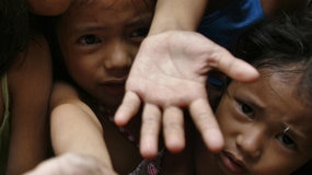Poverty-stricken children reach for food (Reuters: Romeo Ranoco)