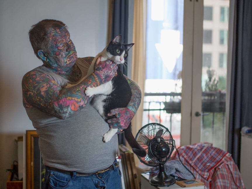 John holds his cat, Lucky Devil.