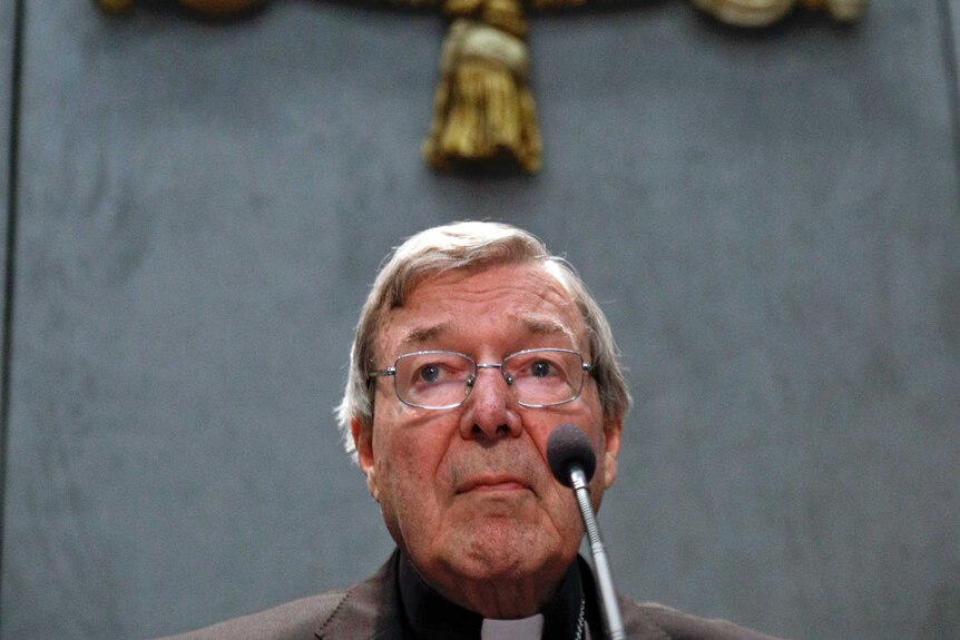 Cardinal George Pell speaks into a microphone during a press conference at the Vatican.