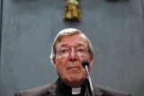 Cardinal George Pell speaks into a microphone during a press conference at the Vatican.