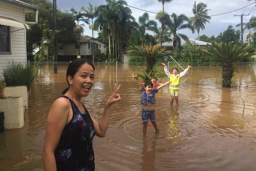 Innisfail resident Ivonne Altmann and three kids in the flooded front yard of her house on March 10, 2018.