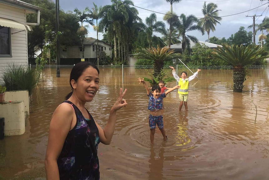 Innisfail resident Ivonne Altmann and three kids in the flooded front yard of her house on March 10, 2018.