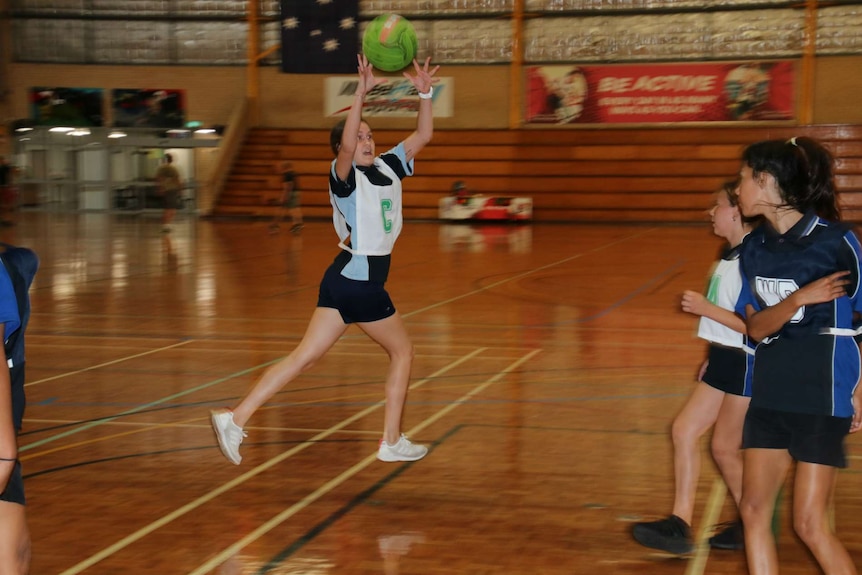 A girl goes to catch a ball at Balga Senior High School.