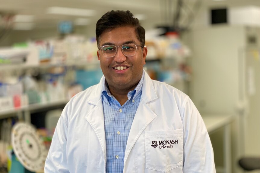 Доктор Ишант Хурана в белом лабораторном халате широко улыбается в камеру.