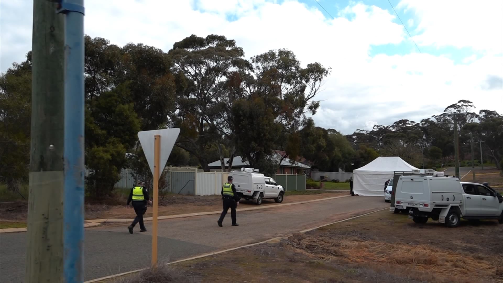 Police walk on a street.