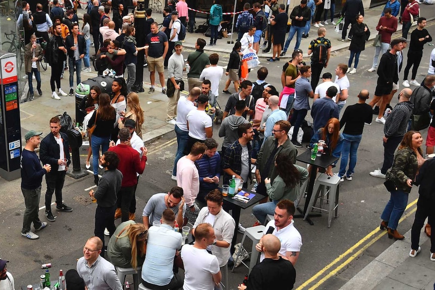 Aerial view of people standing in a street near cafes and shops