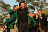 Last year's champion Angel Cabrera presents Mickelson with the green jacket.