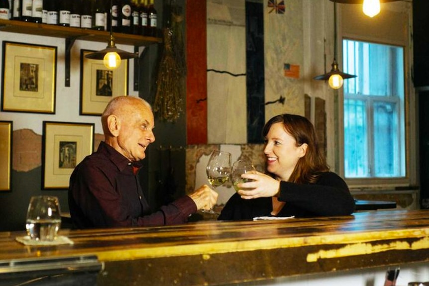 Flip Prior shares a drink with her neighbour in a bar
