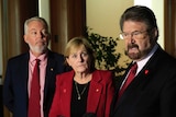 Bruce and Denise Morcombe, parents of Daniel, look on at senator Derryn Hinch as he speaks into a microphone at a presser