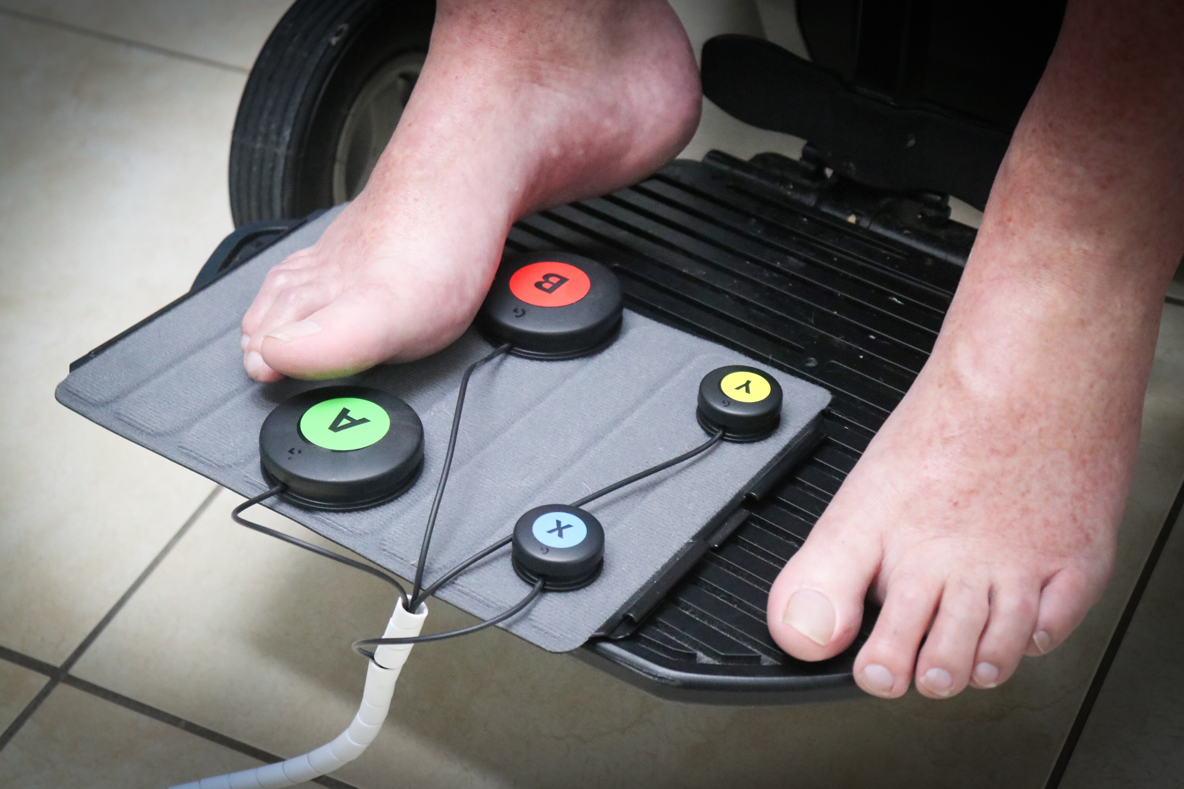 An accessible controller being used by a person's feet on a wheelchair