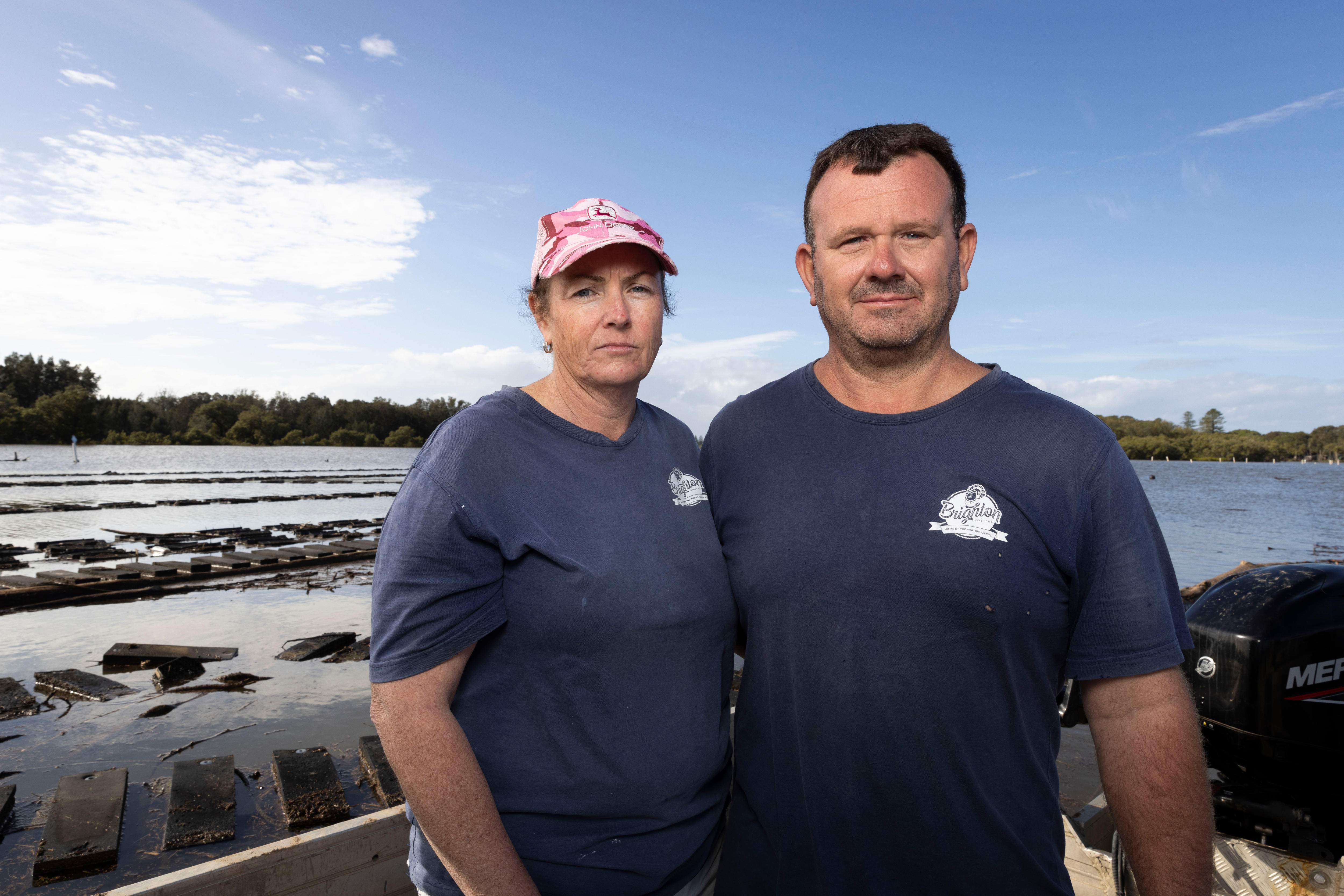 Un hombre y una mujer se encuentran en un barco cerca de las zonas de arrendamiento de ostras.