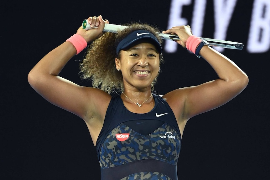 Naomi Osaka raises her arms as she celebrates victory over Jennifer Brady in the Australian Open final.