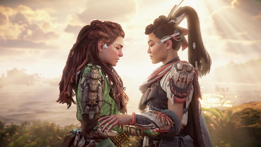 Screenshot from Horizon Forbidden West: two women/warriors having an emotional moment, holding each other, against sunset