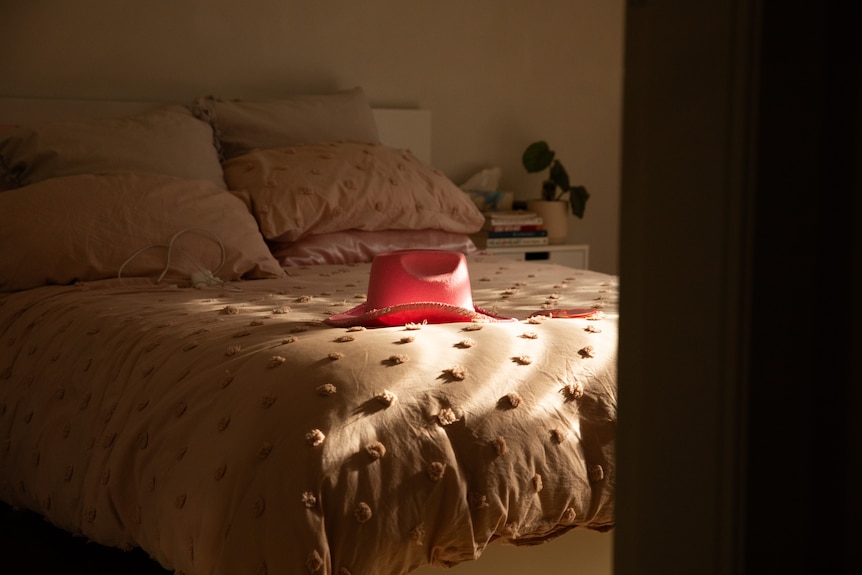 A pink cowboy hat on a bed