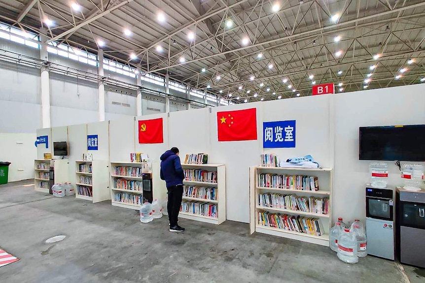 A person examines books in a large centre for patients recovering from COVID-19.