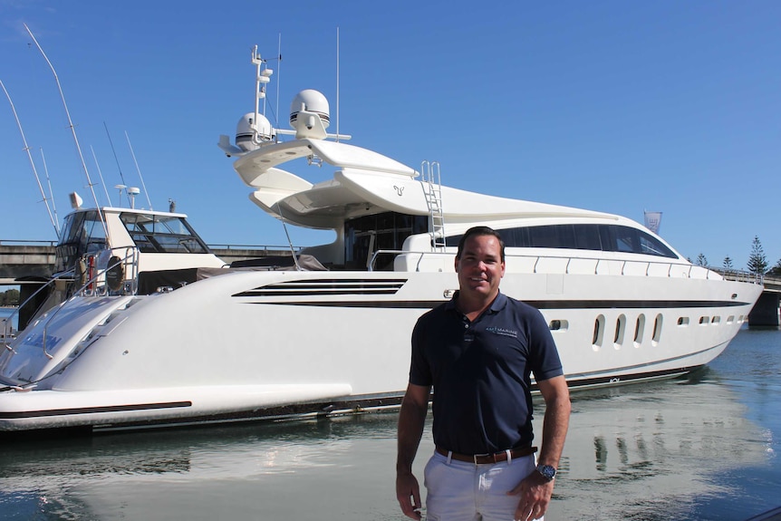 Andy Taylor luxury boat broker standing in front of 101 foot boat at Sovereign Islands