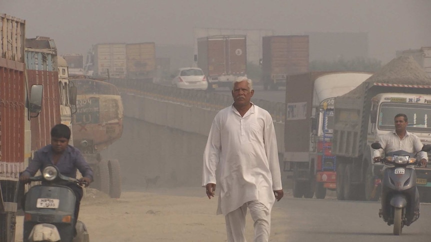 A man walks down a polluted road in New Delhi, India