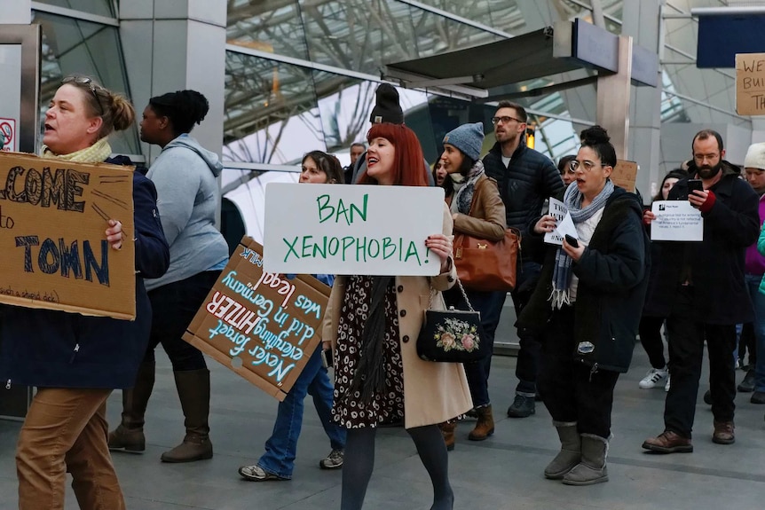 Demonstrators hold signs protesting in and around the main terminal in Portland, Oregon.