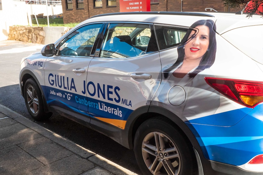 A car in a driveway with Giulia Jones's name and picture on it.