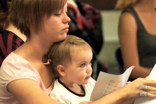 A teenage mother with her daughter in a classroom