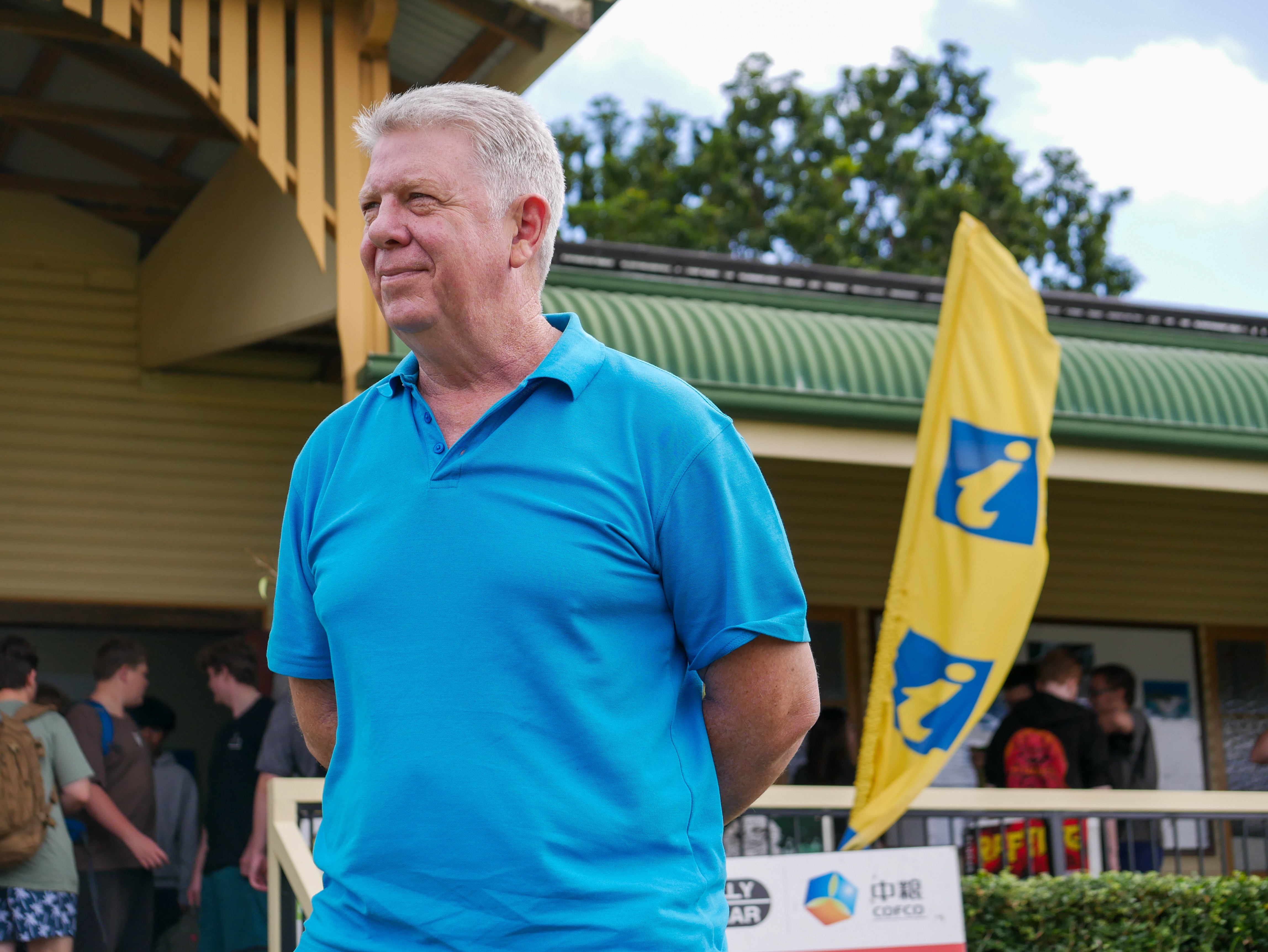 A man standing in front of a yellow visitor information centre sign