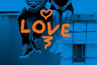 A stylised photo of a young couple sitting on a bench, from the waist down, with the word love emblazoned across the image.