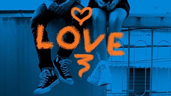 A stylised photo of a young couple sitting on a bench, from the waist down, with the word love emblazoned across the image.