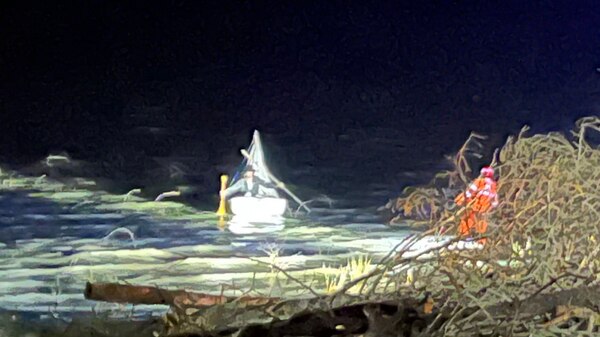 A small boat on the water at night.