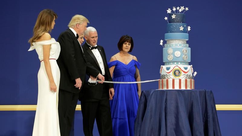 Left to right: Melania Trump, Donald Trump, Mike Pence, Karen Pence stand by nine-tiered cake as Donald Trump cuts it with sabre