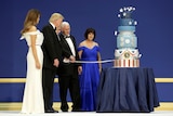 Left to right: Melania Trump, Donald Trump, Mike Pence, Susan Pence stand by nine-tiered cake as Donald Trump cuts it with sabre