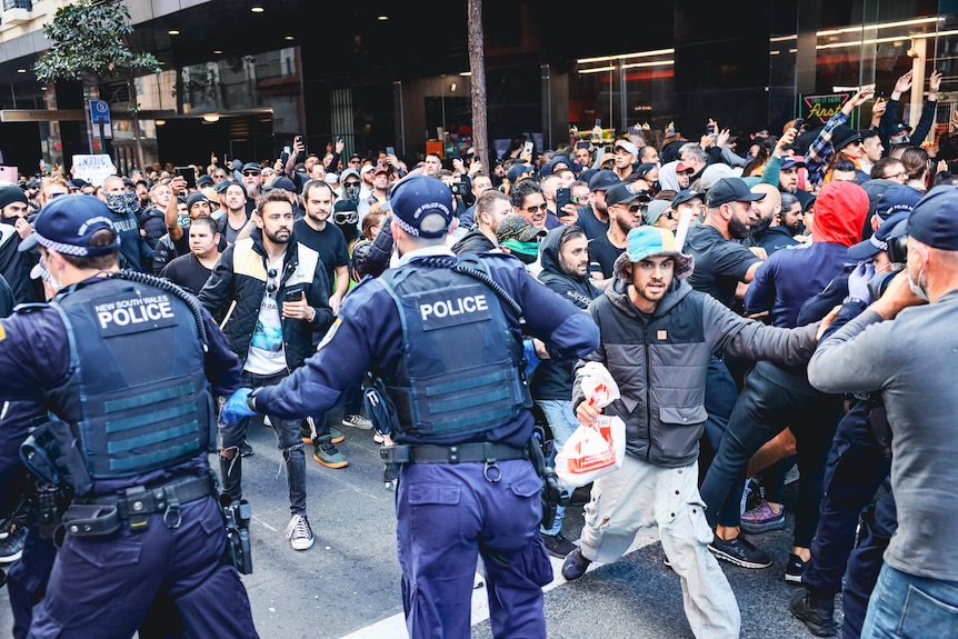 a group of people standing in front of police