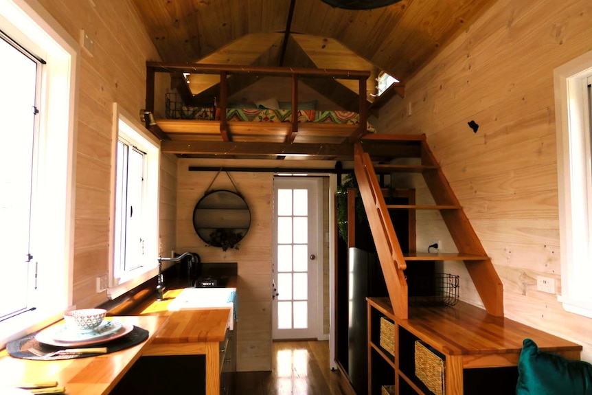 Inside a tiny home, with the bed in an upstairs loft
