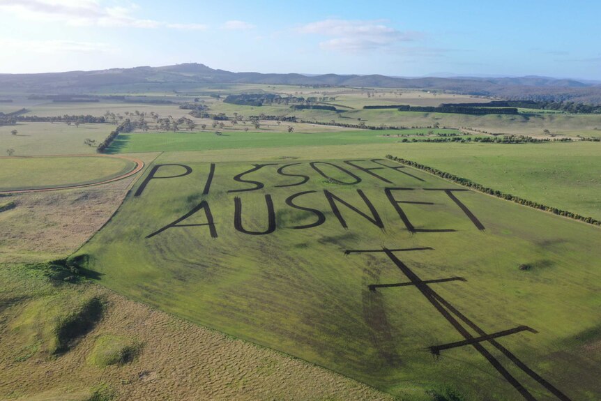 A drone photo of a western Victorian farm with a paddock ploughed to read "piss off Ausnet"