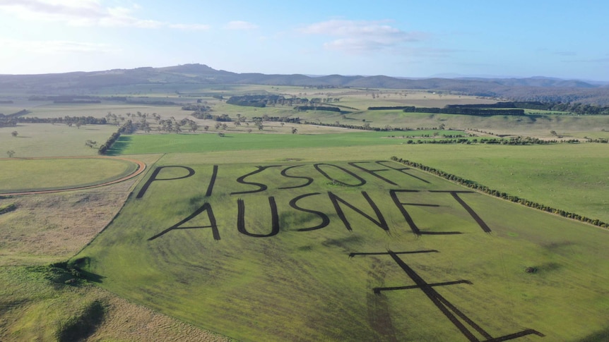 A drone photo of a western Victorian farm with a paddock ploughed to read "piss off AusNet".