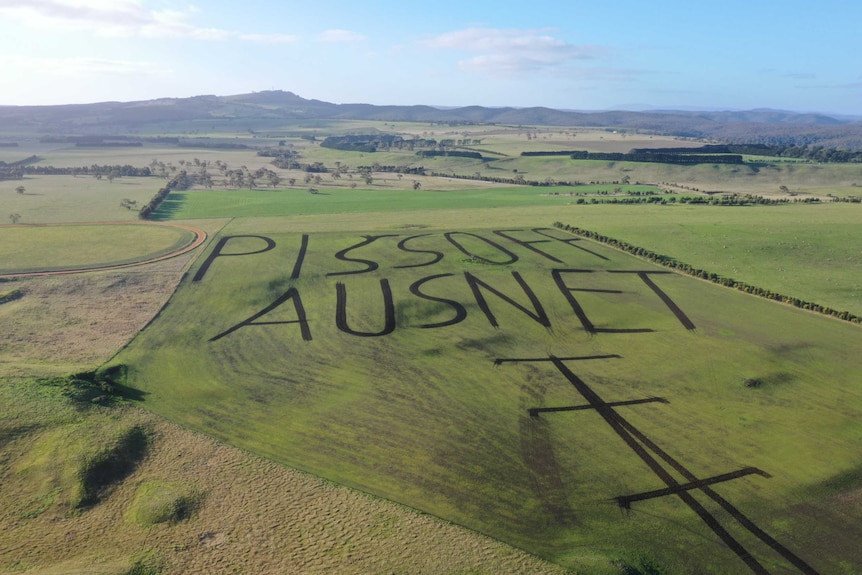 A drone photo of a western Victorian farm with a paddock ploughed to read "piss off AusNet".