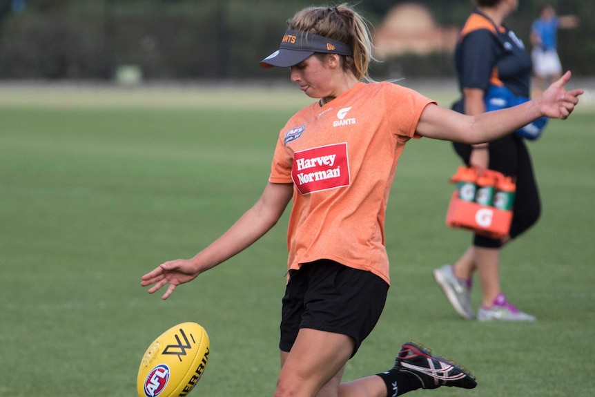 Maddy Collier kicks a football at GWS Giants training.