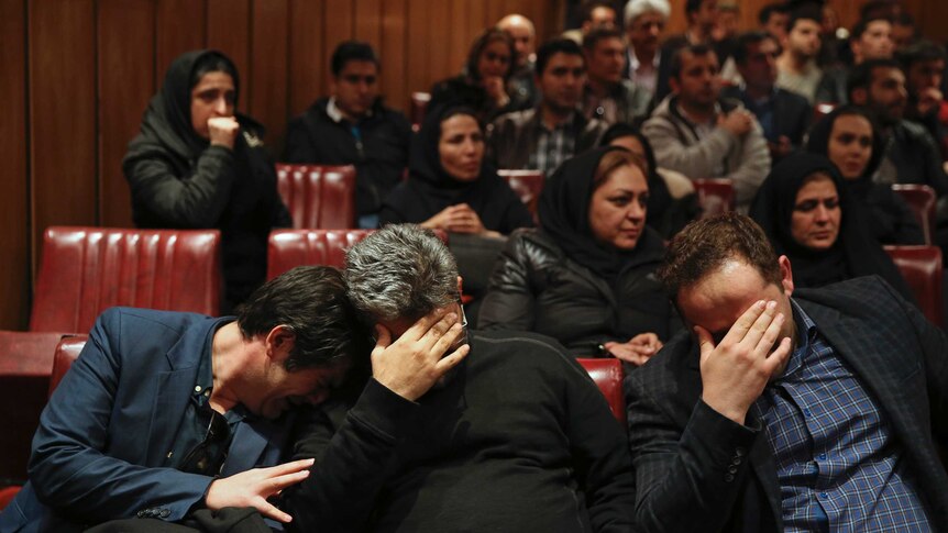 Friends and colleagues of the deceased Iranian seafarers weep at the headquarters of National Iranian Tanker Company.