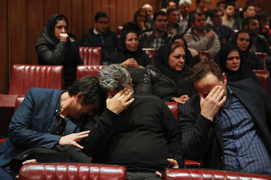 Friends and colleagues of the deceased Iranian seafarers weep at the headquarters of National Iranian Tanker Company.