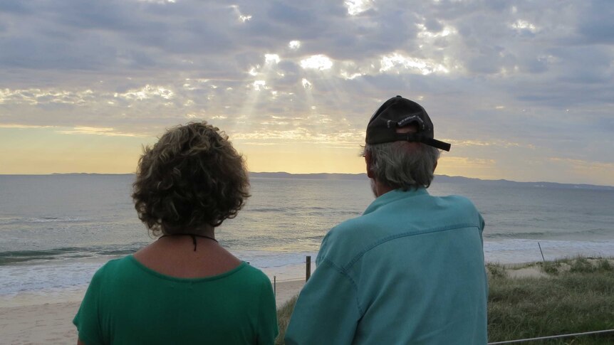 A couple look towards the sunrise from Bribie Island
