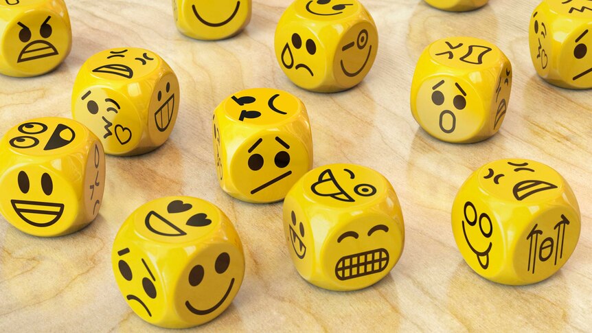 Yellow dice with emoji or emoticon faces.