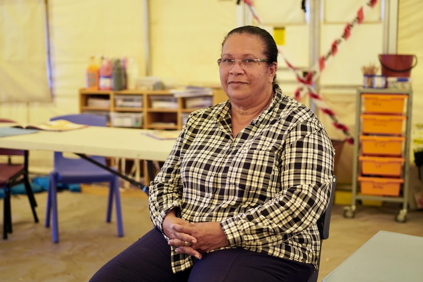 Anne Pollock sits on a chair and looks at the camera.