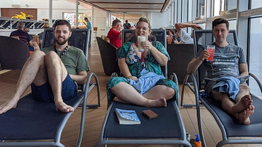 Jason Griffiths, Karla Mathews and Richard Elzer sit on deck chairs looking at the camera