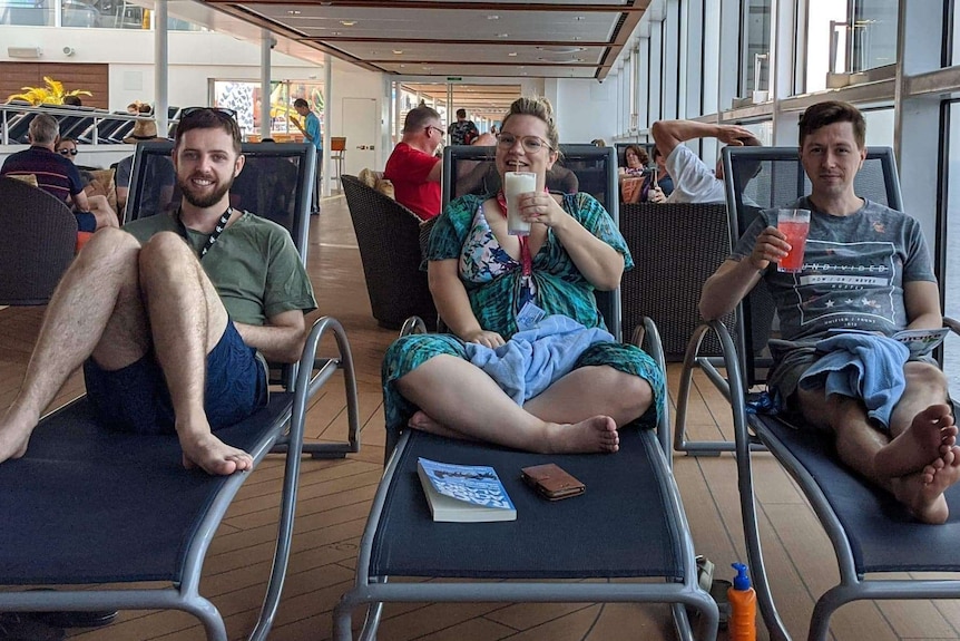 Jason Griffiths, Karla Mathews and Richard Elzer sit on deck chairs looking at the camera