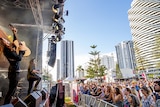 A band performs at Victoria Park in Broadbeach against a backdrop of skyscrapers and pine trees