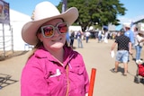Charnie Finnegan wearing faux-diamond encrusted sunnies, pink reflection, pink shirt, big hat.