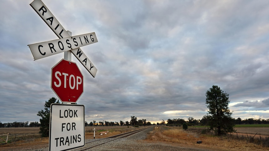 A stop sign at a railway crossing.