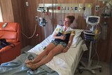 Teenager Bridie lying in a hospital bed after being bitten by a snake.