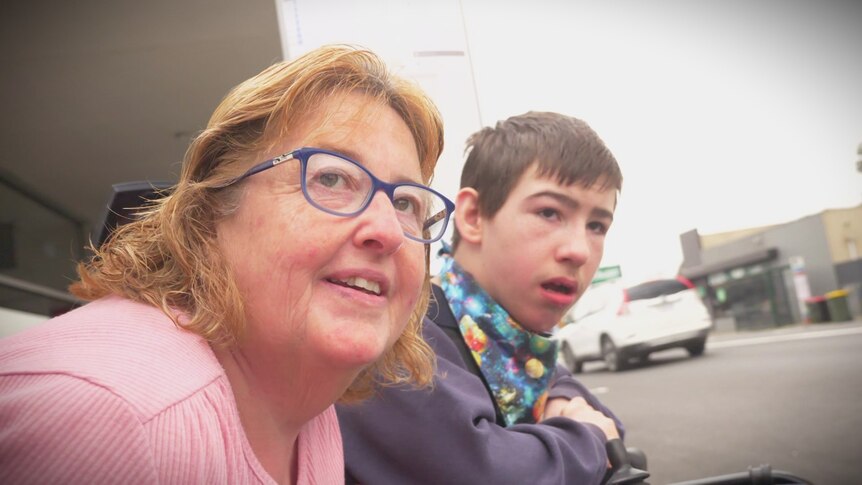 Lynda Goymour with son Mitchell looking up a suburban street.