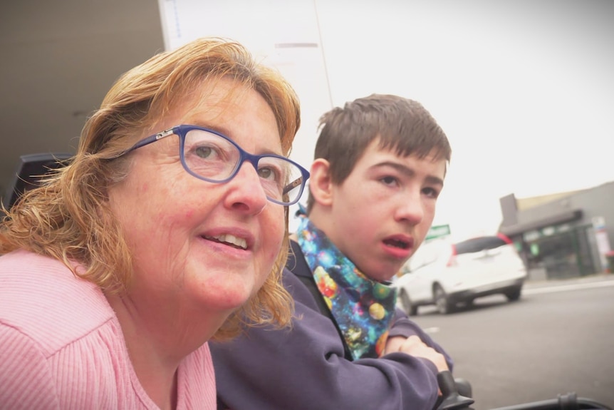 Lynda Goymour with son Mitchell looking up a suburban street.