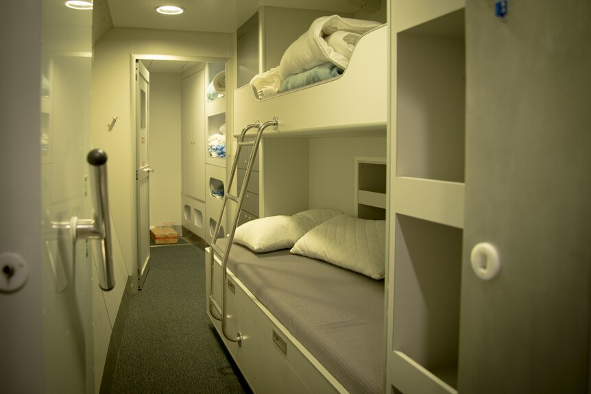 An unoccupied ship's cabin with a double bunk-bed.